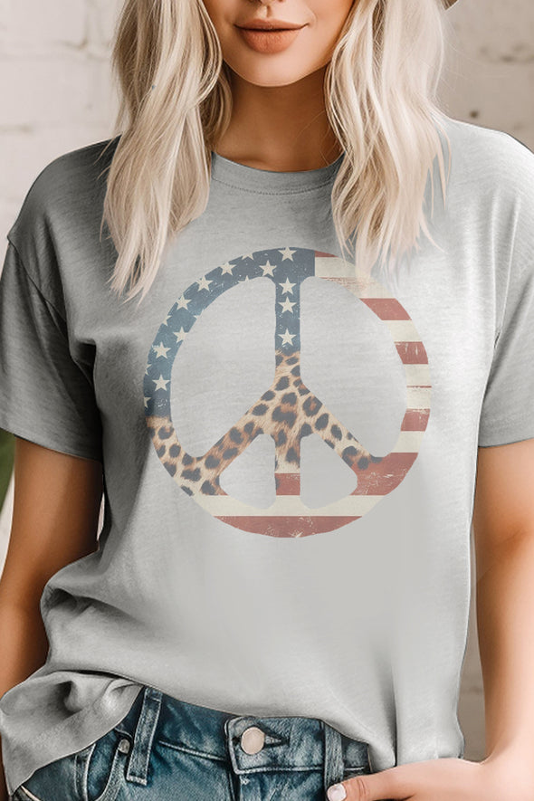 A female model wearing a heather grey short sleeve unisex t-shirt with a peace sign that has the red white and blue American flag and leopard print inside of it on the front