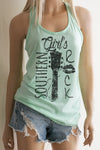 A blonde model wearing shorts and a mint racerback tank top with a black design with the words Southern Girl's Rock with  a guitar neck and strings in the middle. 