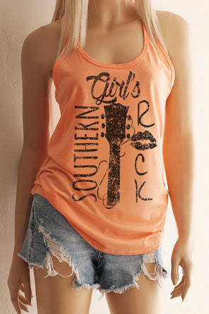 A blonde model wearing shorts and a coral racerback tank top with a black design with the words Southern Girl's Rock with  a guitar neck and strings in the middle. 